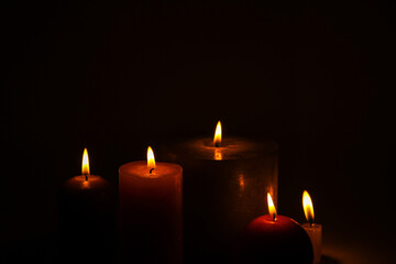 Flaming candles on a dark black background