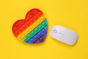 Antistress pop it sensory toy with pc mouse on yellow background