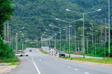 The road is full of electric poles and wires cables.
