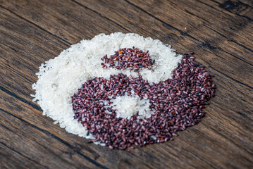 Rice and black rice placed on a wooden table to form a tai chi gossip diagram