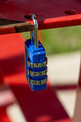 Small blue combination lock on a red background