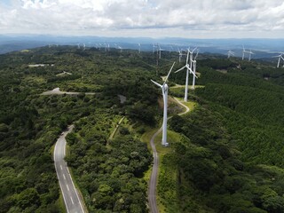 青空の青山高原の風車群とスカイラインをドローンで空撮した写真