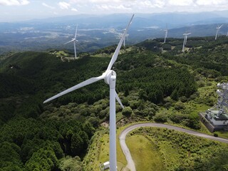 青空の青山高原の風車群をドローンで間近で空撮した写真