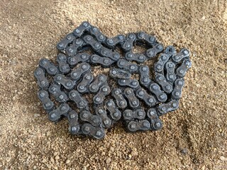 Black roller chain texture on the ground