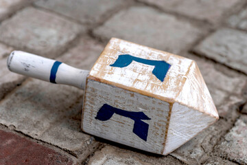 Dreidel also dreidle or dreidl with blue lettering. Four-sided spinning top, played during the Jewish holiday of Hanukkah Jewish variant on the teetotum. Wooden gambling toy