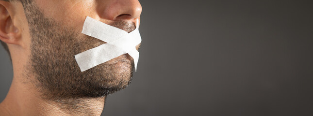 Caucasian man with tape on mouth. Censorship - obrazy, fototapety, plakaty