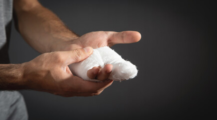 Caucasian man with bandage in injured hand.