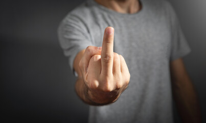 Caucasian man showing middle finger.