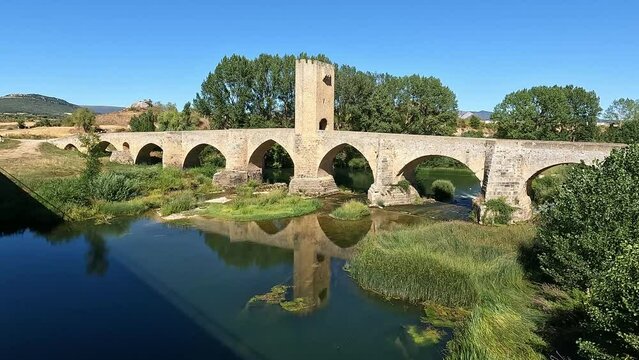 Reflejo sobre el agua del r&iacute;o Ebro del puente medieval de origen rom&aacute;nico y torre fortificada siglo XIV en la villa de Fr&iacute;as, provincia de Burgos, Espa&ntilde;a