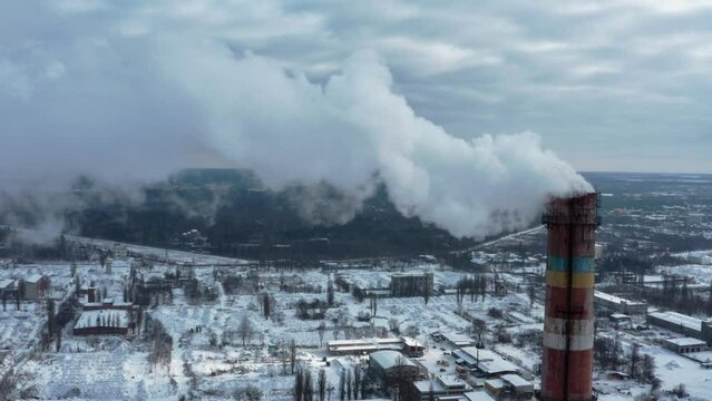Pollution of the atmosphere by an industrial enterprise of the TPS station. Cloudy day in the winter. Smog smoke carbon and pollution emissions from industry smokestacks.  Cinematic footage