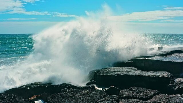 Large ocean waves crash about the  pier - slow motion. Big waves is  crashing on rock creating huge splashes. Beautiful azure ocean waves crashing about cape.  Powerful nature energy. Portugal.