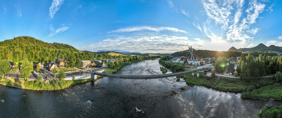 Aerial view of the bridge and the High Tatras in the village of Cerveny Klastor in Slovakia - obrazy, fototapety, plakaty