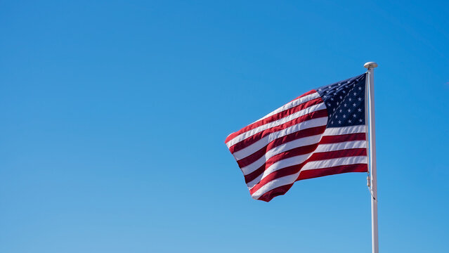American flag raised against clear blue skies