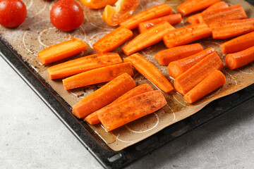 Fresh carrots, orange bell pepper and tomatoes cut in long strips placed on on the oven rack ready...