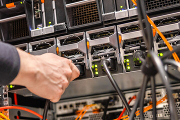 Close-up of Male Technician Plugging Computer Cable In San