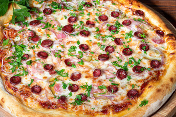 Pizza with bacon and cheese, herbs and cherry tomatoes. With mozzarella, shrimp and octopus, mussels and other products on a wooden background.