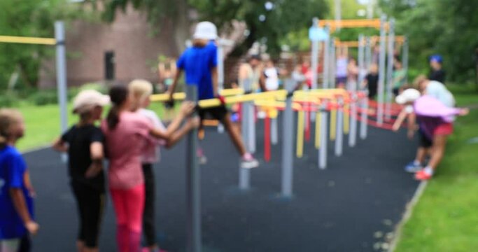 School-age children play sports in the playground. Happy teenagers play together outdoors. Out of focus 4k