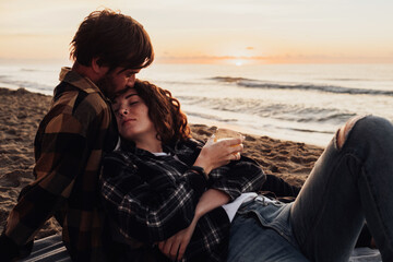 Woman leans in her boyfriend, young couple meets dawn on the seashore together