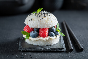 Aromatic sushi burger with raspberries and blueberries as Japanese cuisine.
