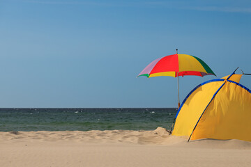 Fototapeta na wymiar Mockup of summer landscape with beach umbrella. Blue sea or ocean background. Summer holiday concept. Beautiful beach banner.