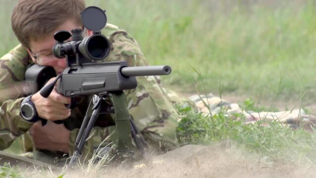 Sniper Shot from Rifle. The sniper looks through the optical sight of the rifle and fires a shot