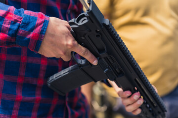 Close up of man's arms holding uzi gun. Firearm training. Horizontal outdoor shot. High quality photo