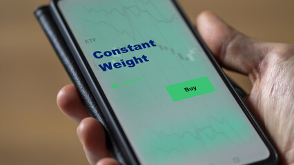 An investor's analyzing the constant weight etf fund on a screen. A phone shows the prices of equal weighting ETFs.	