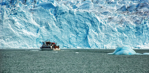 Cruise boat in front of Perito Moreno Glacier in Patagonia, Argentina, South America; guided boat tour on lake.