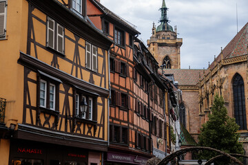 Colmar, Alsace, France, 4 July 2022: town capital of Alsatian wine, narrow picturesque street with medieval colorful houses, Timber framing or post-and-beam construction,