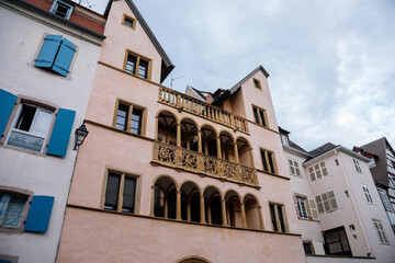 Colmar, Alsace, France, 4 July 2022: town capital of Alsatian wine, narrow picturesque street with medieval colorful houses, Timber framing or post-and-beam construction, carved stone arches