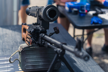 Close up front view of rifle gun scope and barrel standing on table at gunsmith workshop. Horizontal shot. High quality photo