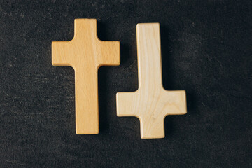 Obraz premium Wooden cross on a new black plastered brick wall. Concept of Religion