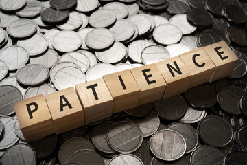 我慢・忍耐のイメージ｜「PATIENCE」と書かれたブロックとコイン
