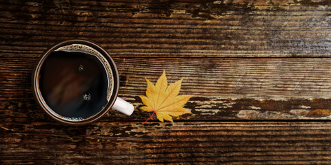Drinking Coffee in Fall and Autumn Season. Hot Coffee Cup on Wooden Table. Top View. Selective Focus. blurred Maple Leaf as background