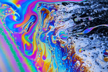 Fototapeta na wymiar Macro photo of colourful pastel swirly patterns of a soap bubble