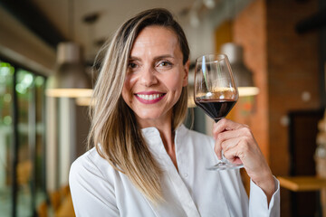 One happy caucasian woman with glass of red wine standing happy smile