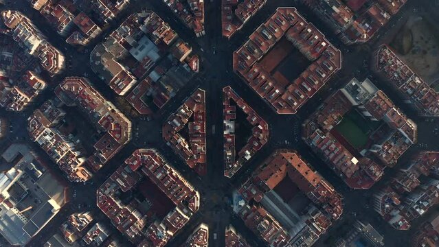Regular square blocks in urban borough divided by Avinguda Gaudi. Top down shot of town development at golden hour. Barcelona, Spain