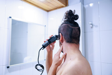 髪の毛をセルフカットする男性の後ろ姿 - obrazy, fototapety, plakaty