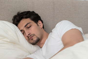 Young handsome man sleeping in the bed at the morning time