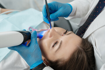 Closeup of female patient in dental chair on a procedure of intraoral digital scan of her teeth