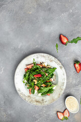 Fresh vegetarian salad with kale, strawberry, spinach leaves and feta cheese. vertical image. top view