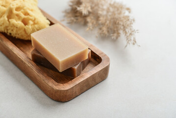 Natural soap bars and pumice stone on wooden tray