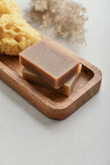 Natural soap bars and pumice stone on wooden tray