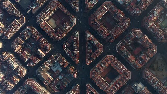 Top down panning view of symmetrical town development in Eixample district at golden hour. Barcelona, Spain