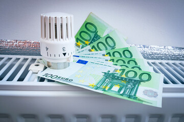 Radiator thermostat valve head with the Euro cash on the home heater. Symbolic image of payment for...