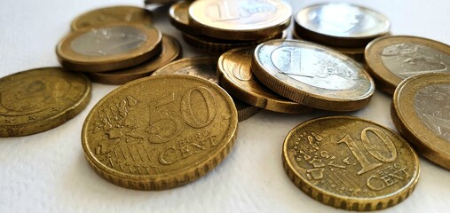 Euro coins on a white background. Money background. Euro currency in Europe. One euro, fifty cents, twenty cents and ten cents. Euro coins in a spoon.