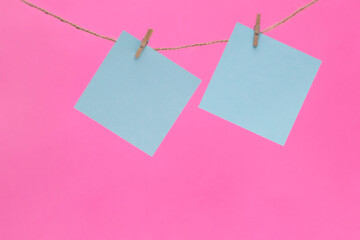 .Two bright yellow stickers are hung on a rope with clothespins.