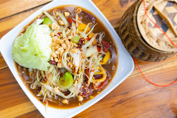 Papaya salad (som tam thai), sticky rice in bamboo container, Thai food ..
