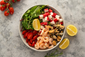 Fresh sea food salad with green mix, cherry tomatoes, herbs and olive oil, lemon dressing. Healthy food