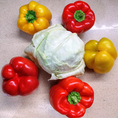 Raw whole white cabbage and colorful bell peppers. Fresh vegetables for cooking on the kitchen worktop